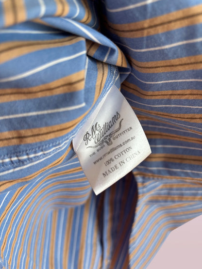 Close-up of a striped shirt with a label on a pink background