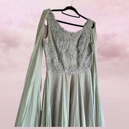 Mint green dress with lace detailing on a hanger against a pink background