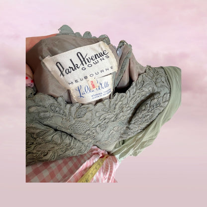 Green lace gauze with 'Park Avenue Gowns Melbourne' label on a pink checkered background