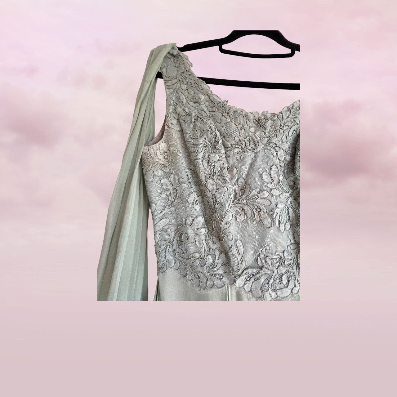Silver evening gown with floral lace details on a pink background