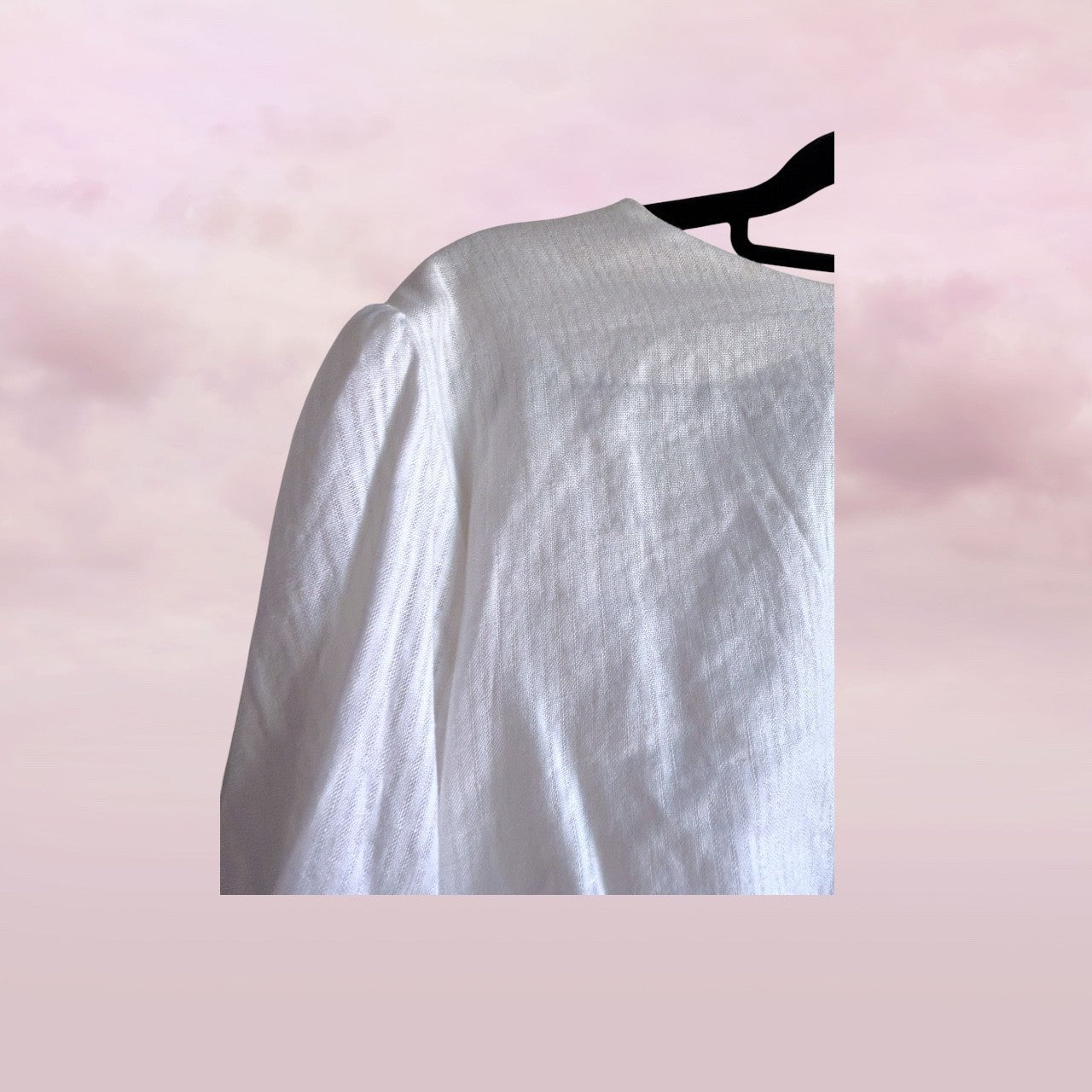 White shirt on a hanger against a pink background
