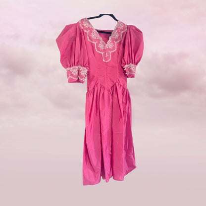 Pink dress with lace details on a pink background