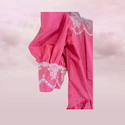 Pink garment with lace detailing on a light pink background