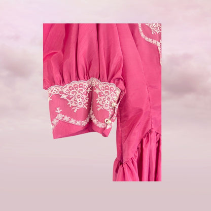 Pink garment with white lace details on a light pink background