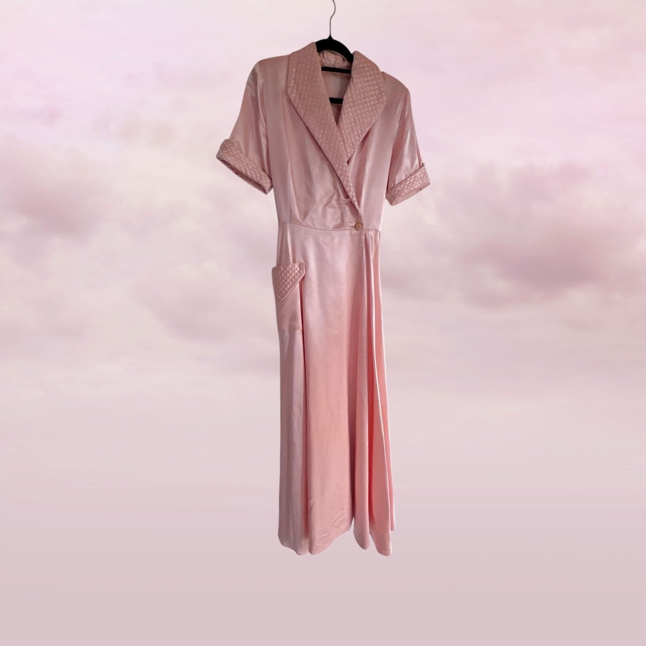 Pink dress on a hanger against a pink background