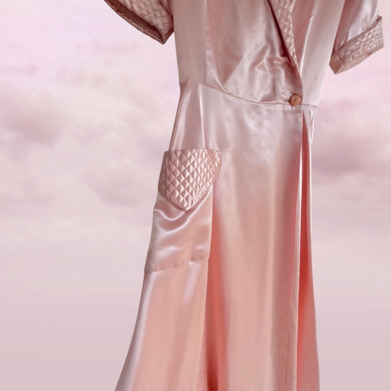 Pink satin nightgown with lace trim on a pink background