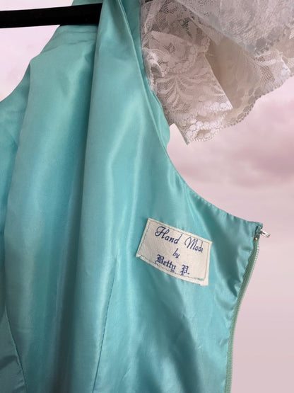 Teal garment with a label on a pink background