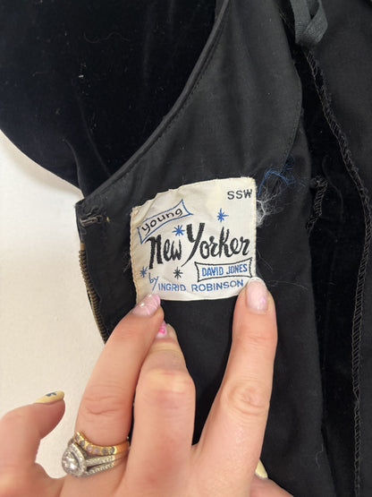 Close-up of a 'Young New Yorker' label on a black garment with a hand holding it.