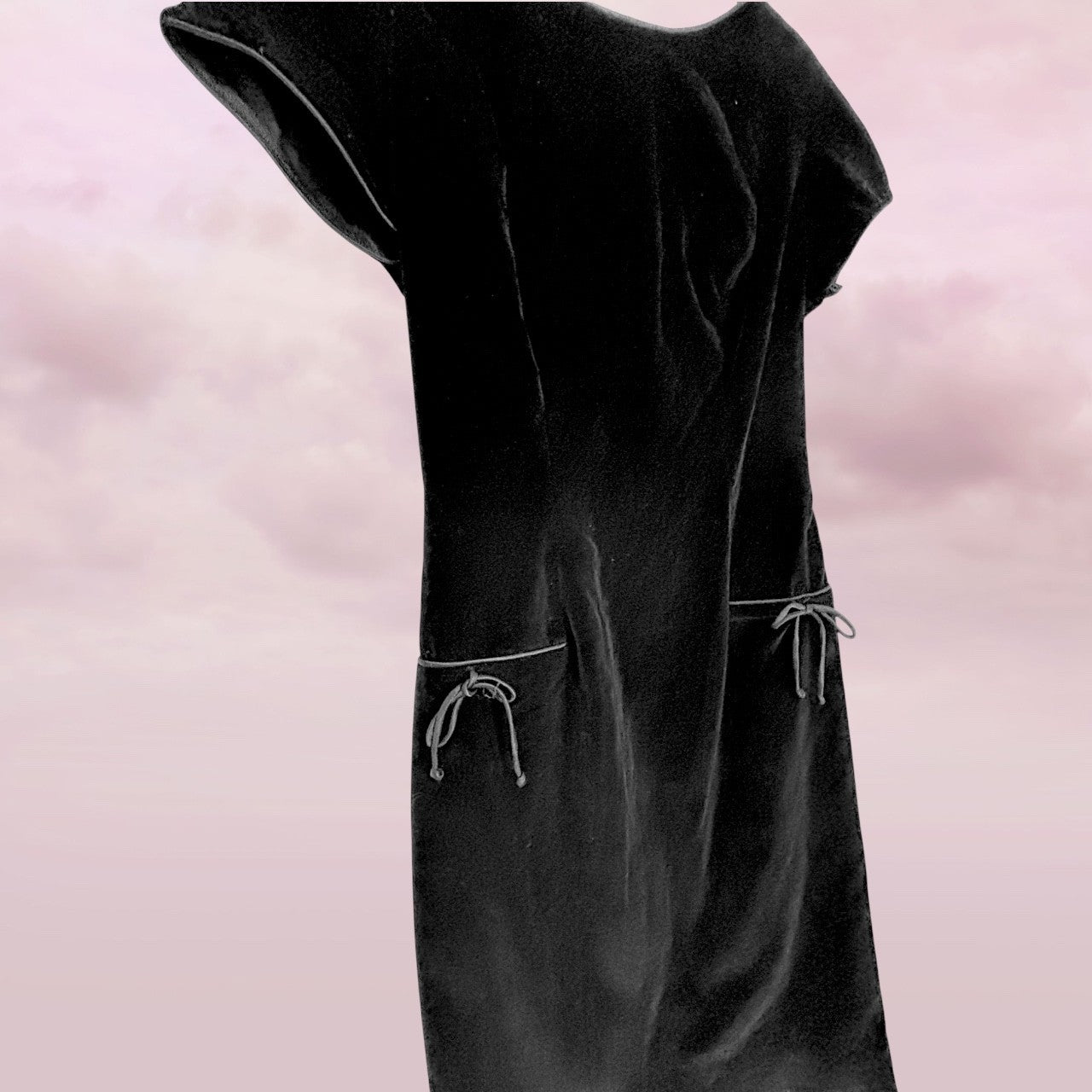 Black dress with sheer sleeves on a pink background