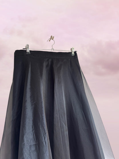 Black skirt with sheer overlay on a pink background