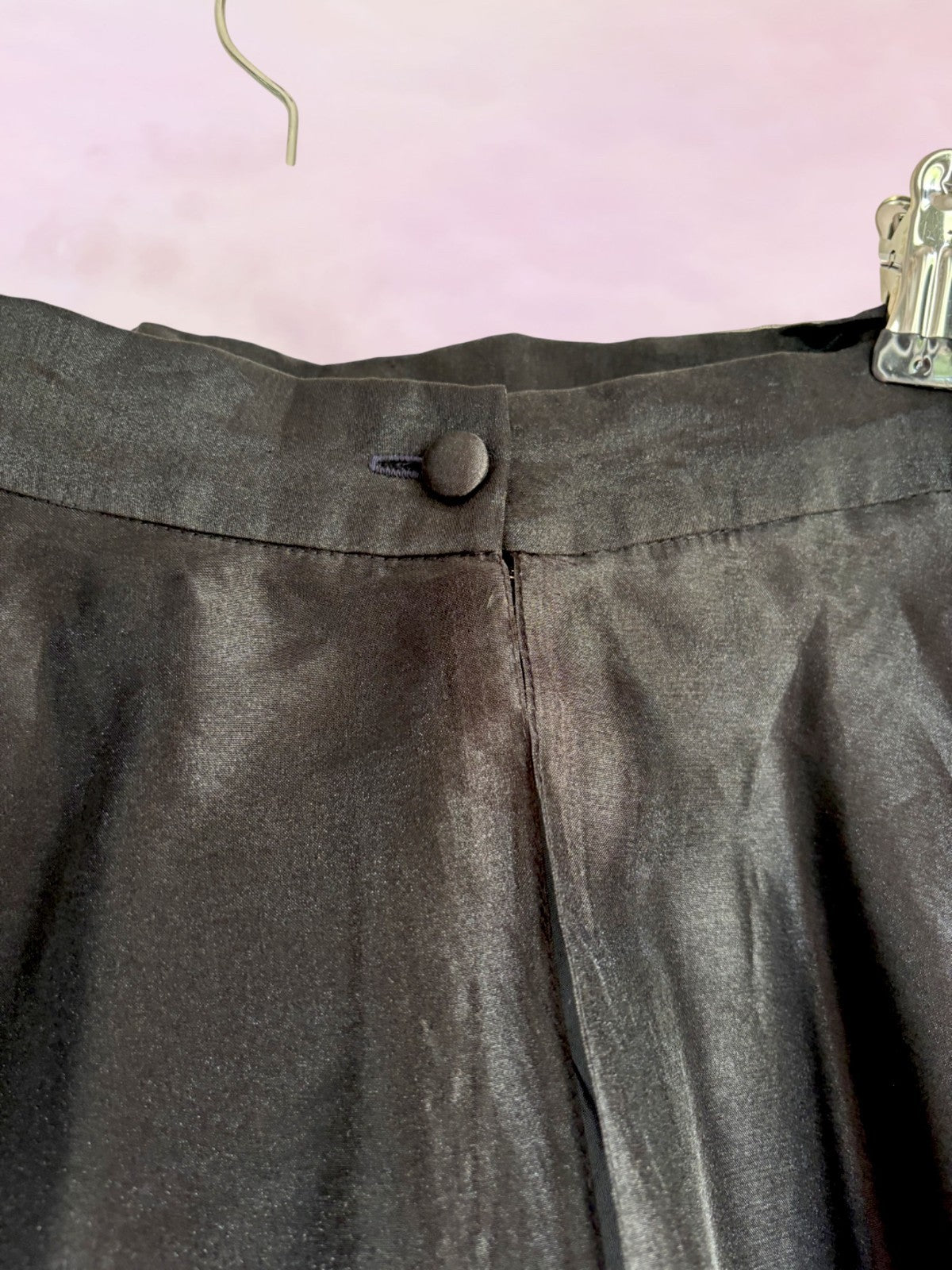 Dark gray skirt with a button on a pink background