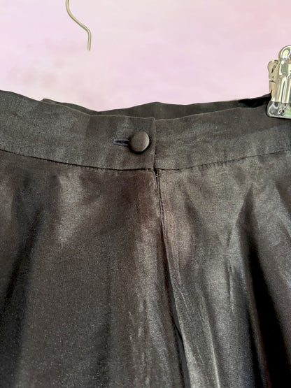 Dark gray skirt with a button on a pink background