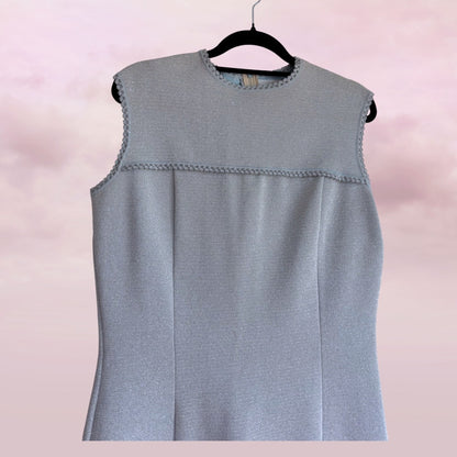 Gray sleeveless top on a hanger against a pink background