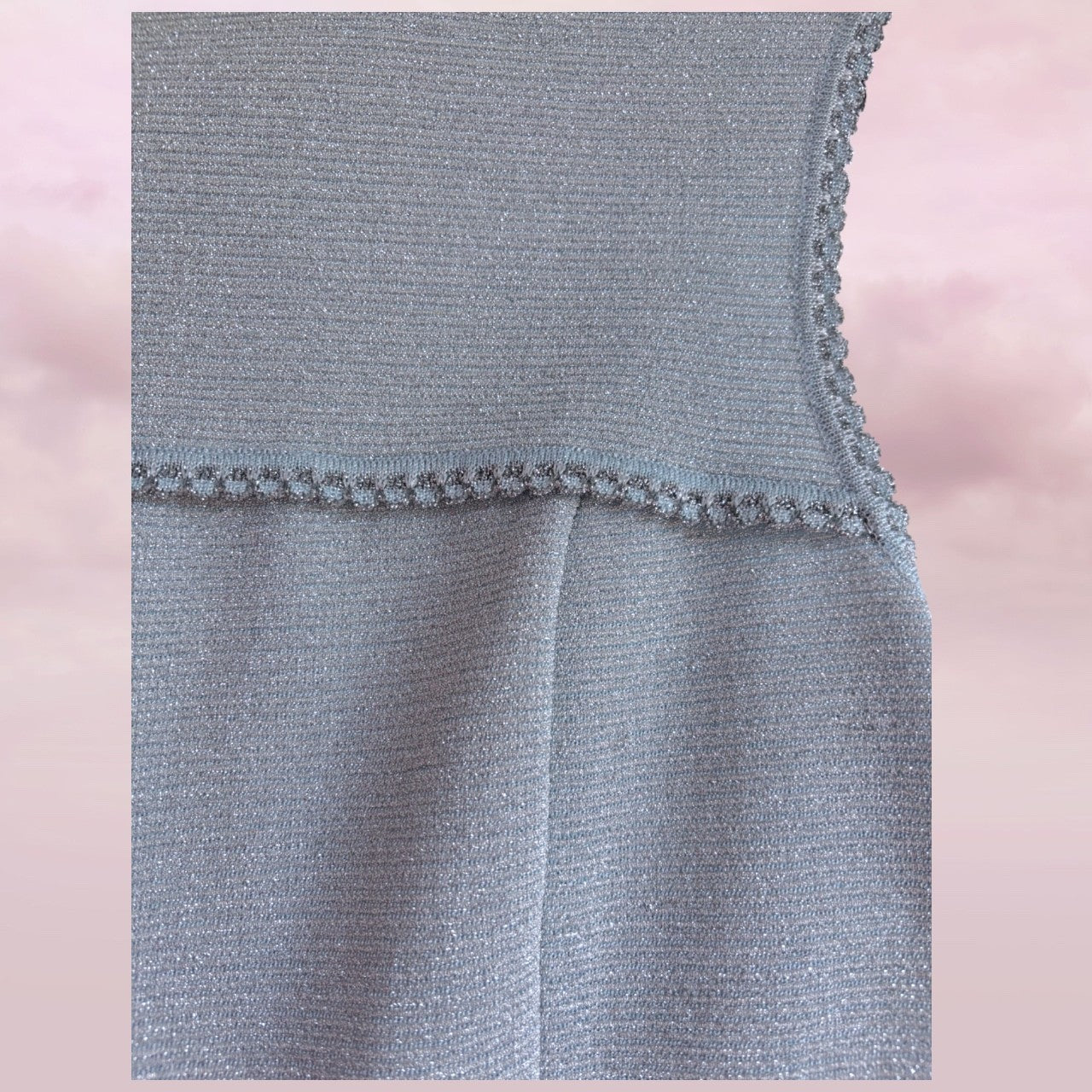 Close-up of a gray textured fabric with a pink blurred background