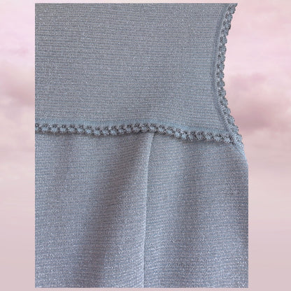 Close-up of a gray textured fabric with a pink blurred background