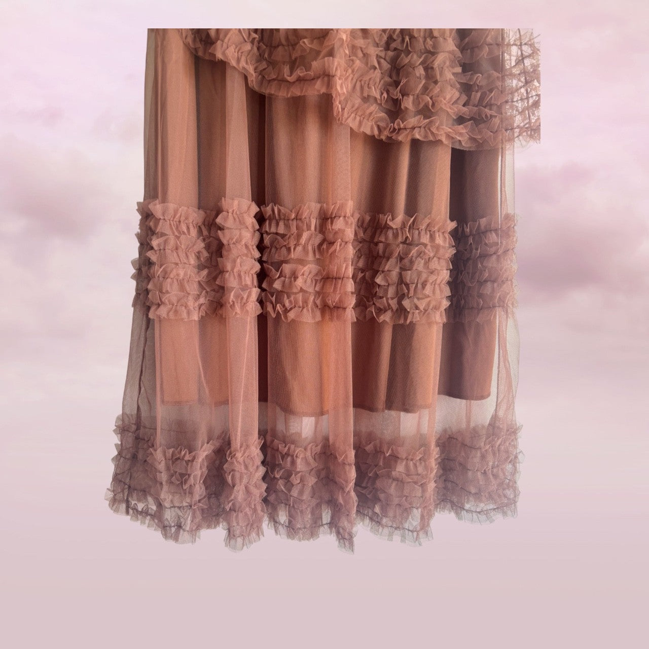 bottom of  skirt with ruffled top and bottom on a soft pink background