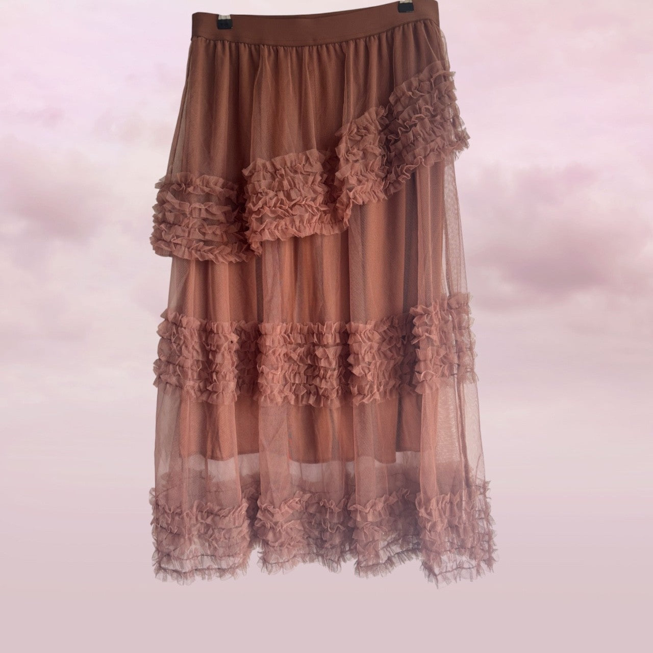 Brown ruffled skirt on a light pink background