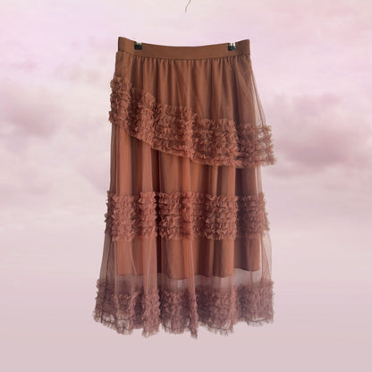 Brown ruffled skirt on a hanger against a pink background