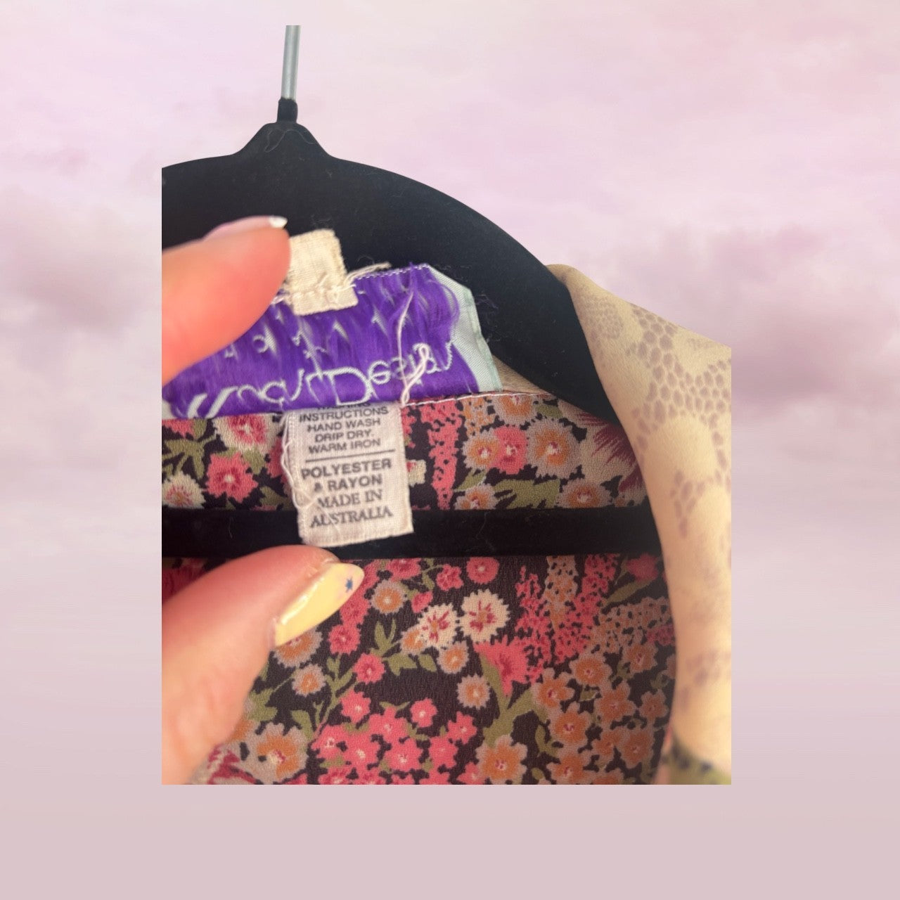 Close-up of a fabric label on a floral-patterned garment with a pink background.