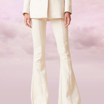 White pants worn by a person on a pink background