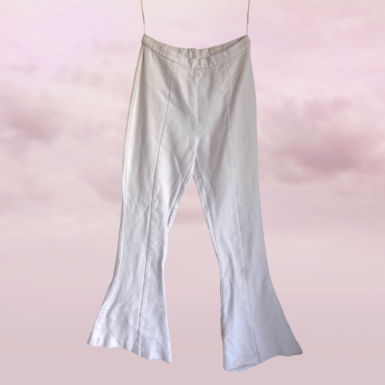 white bell-bottom pants on a pink background