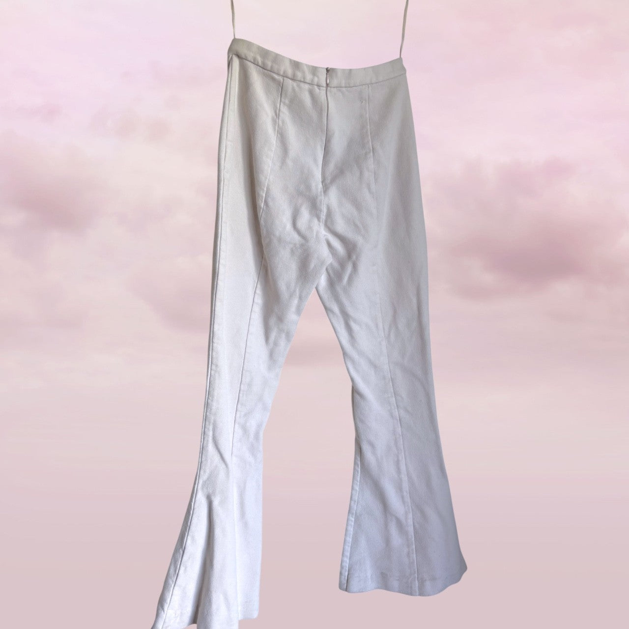 white pants on a pink gradient background