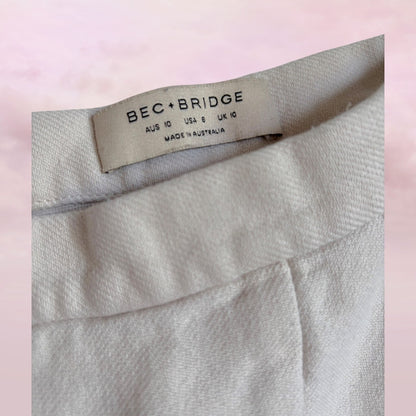 Label on a garment with 'BEC BRIDGE' branding against a pink background