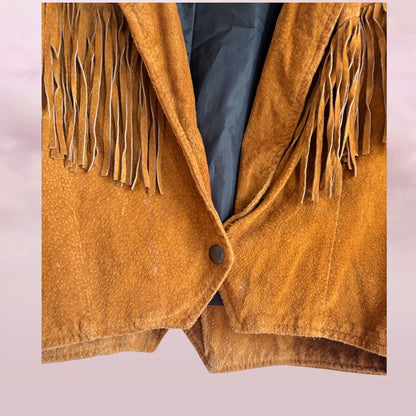 Brown suede jacket with fringes on a light pink background