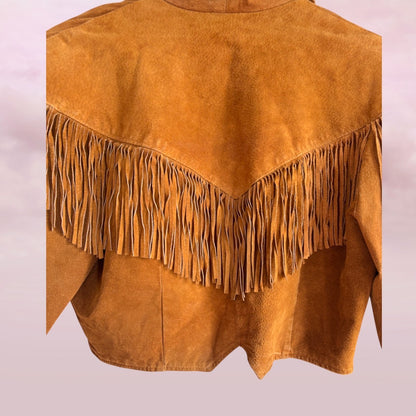 Brown suede jacket with fringes on a light pink background