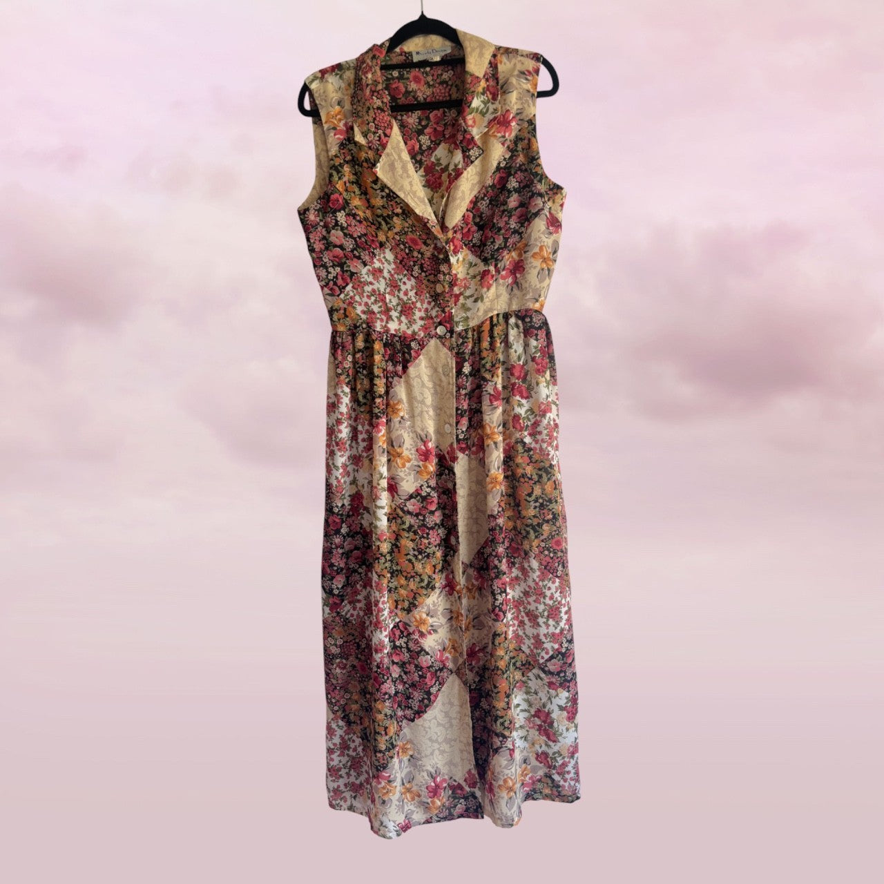 Floral dress on a hanger against a pink background