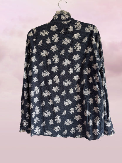 Black floral patterned blouse on a pink background