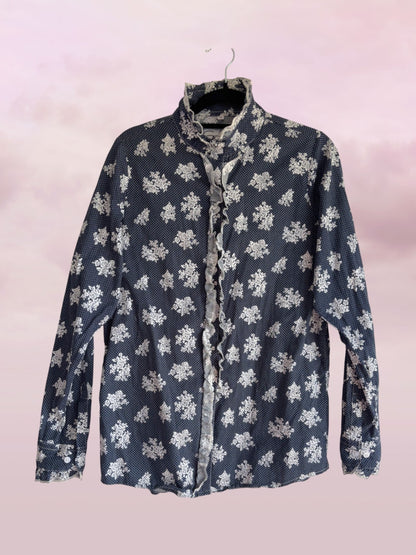 Floral-patterned shirt on a hanger against a light pink background