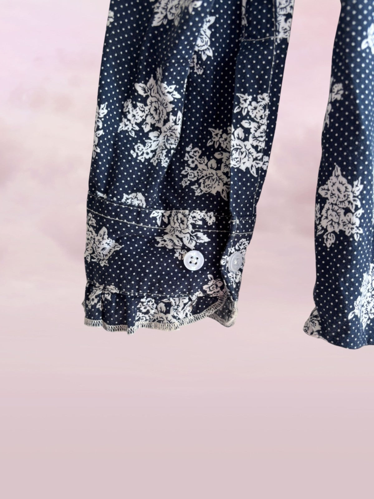 Navy blue shirt with white floral pattern on a pink background