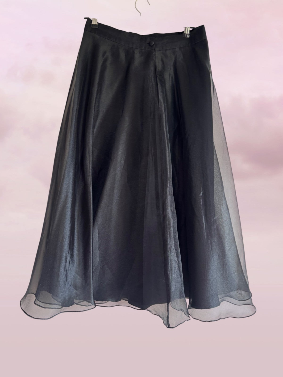 Black skirt with sheer overlay on a light pink background