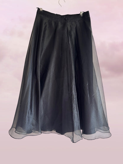Black skirt with sheer overlay on a light pink background
