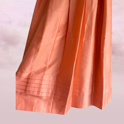 Close-up of an orange skirt with a soft focus background