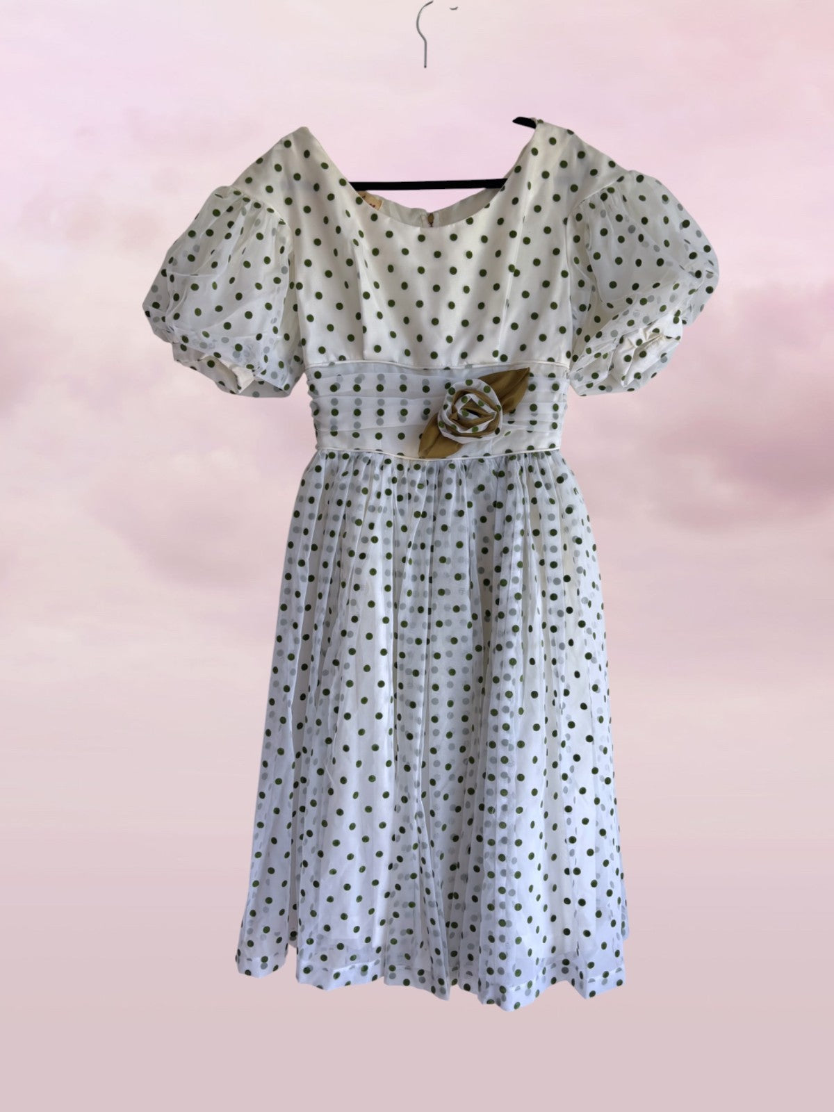 Polka dot dress with a belt on a pink background