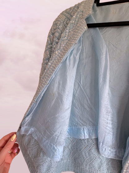 Light blue fabric draped over a textured surface with a hand holding it.