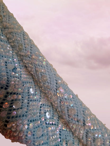 Close-up of a textured fabric with sequins on a light background