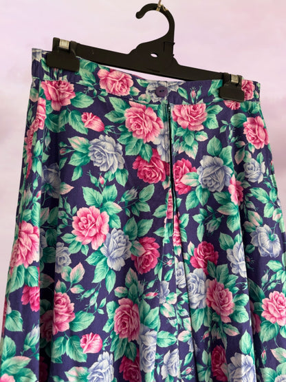 Floral patterned skirt on a hanger against a light pink background