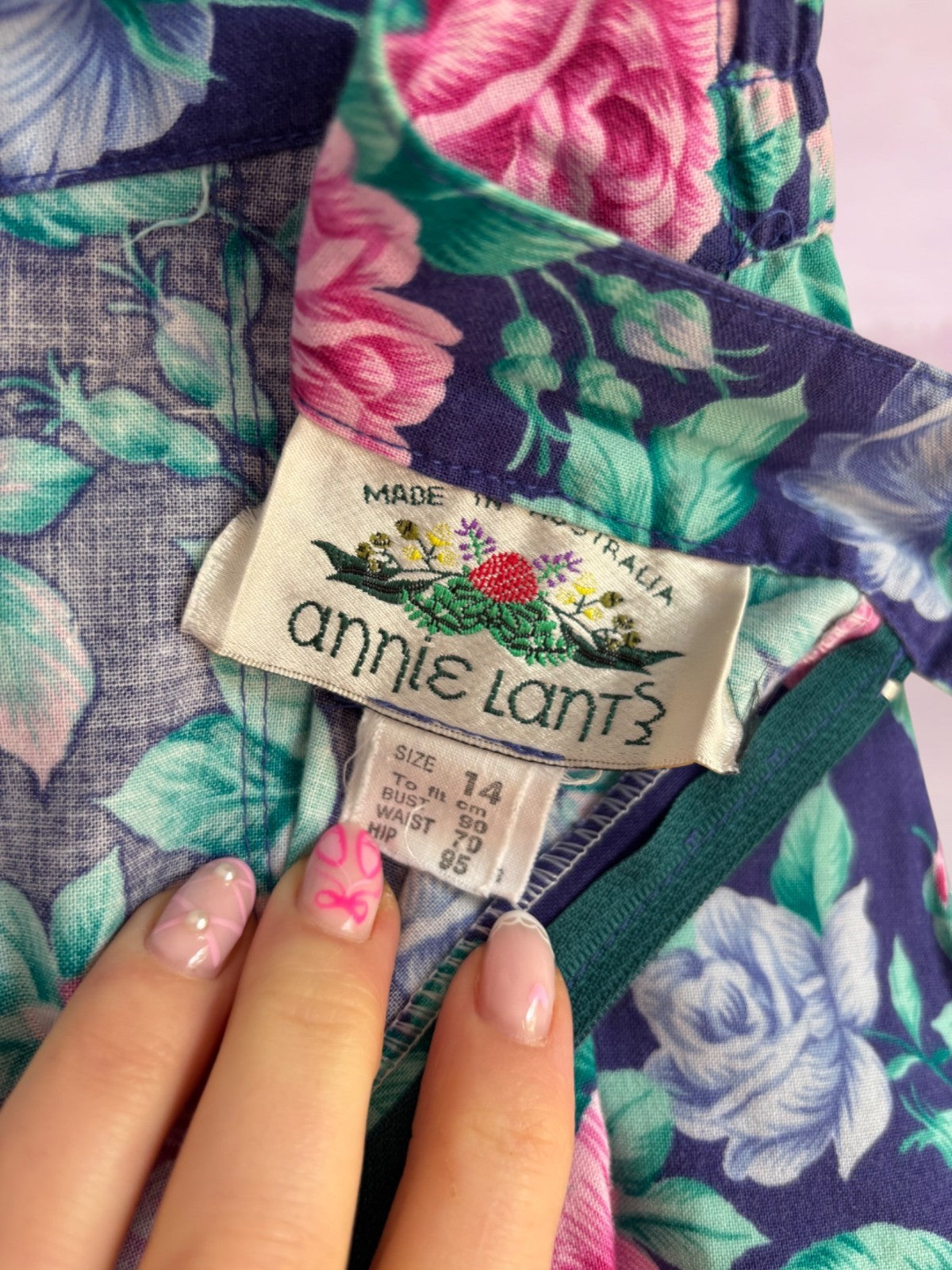 Floral fabric with an 'annie lant?' label held by a hand.