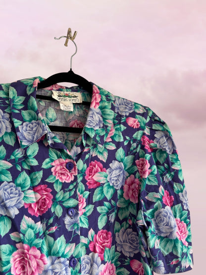 Floral patterned shirt on a hanger against a light pink background