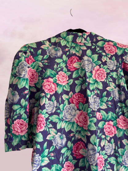 Floral patterned garment on a hanger against a white background