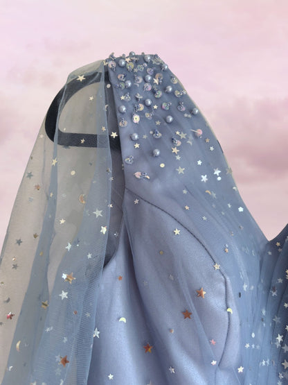 Blue dress with star patterns on a light pink background