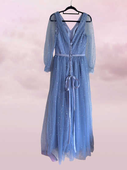 Blue sparkly dress on a hanger against a light pink background