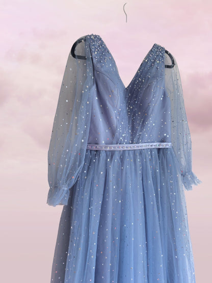 Blue evening gown with sheer sleeves on a pink background