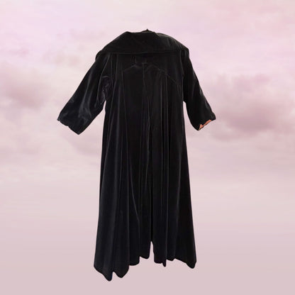 Black graduation gown on a pink gradient background