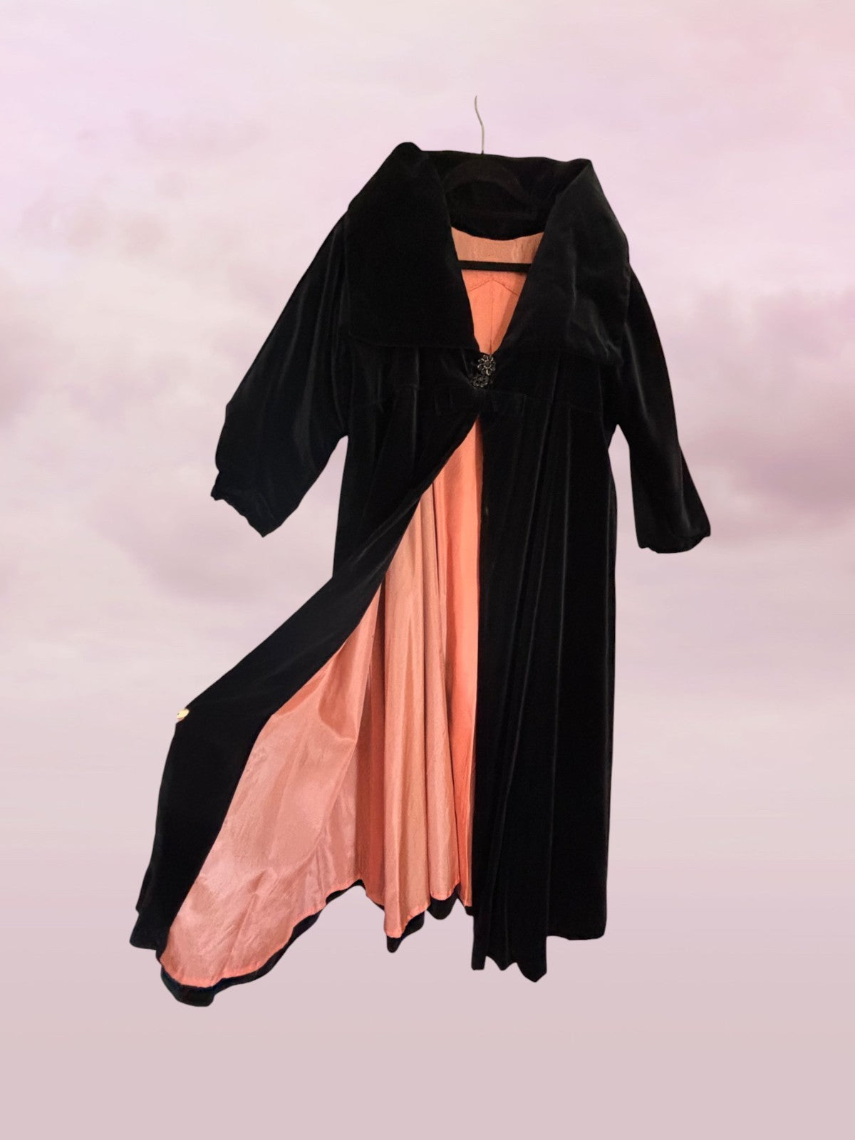 Black coat with pink dress underneath on a white background