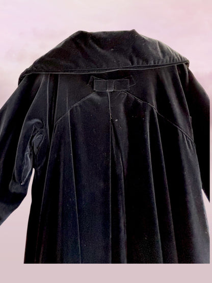 Black coat with a hood on a light pink background