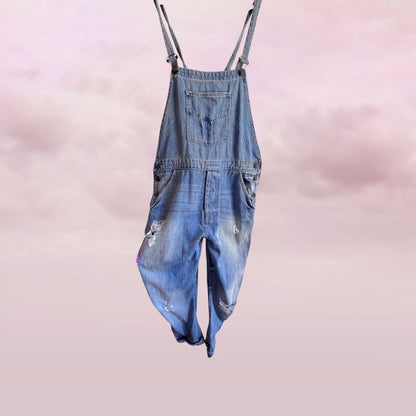 zara Blue denim distressed overalls on a pink background front view 